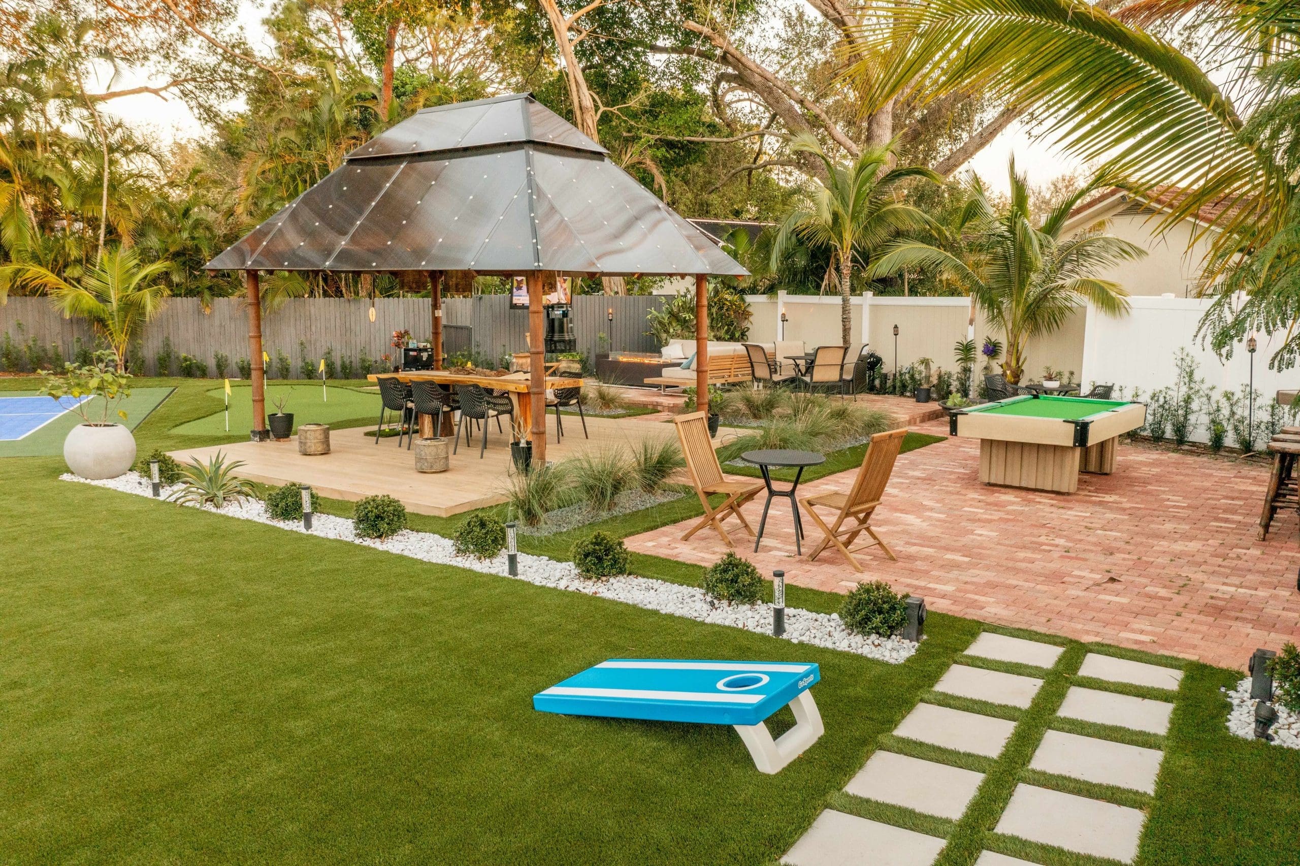 Landscaped backyard with artificial turf, brick patio, gazebo and outdoor seating